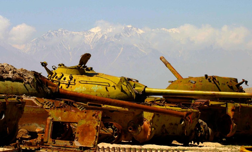 Graveyard of Russian tanks surrounded by snowy mountains, Afghanistan