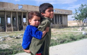 Boy and girl outside bombed out school, Afghanistan